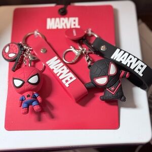 Pair of Spider-Man keychains in red and black. Features Marvel logo on straps.